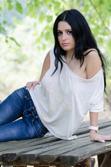 Naklejka premium Woman in white shirt and jean lie over wooden surface