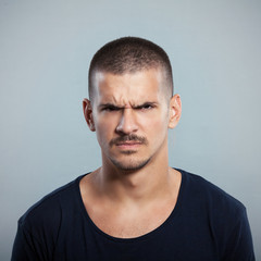 Obraz premium Portret młodego mężczyzny marszczącego brwi. Strzał studio.