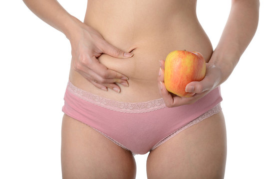 Beautiful slim woman holding apple while checking her fat,Diet c