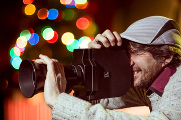 A man wearing a cap with an old movie camera