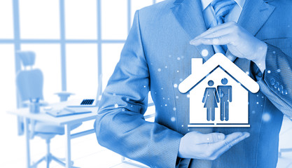 businessman protecting family in home with hands