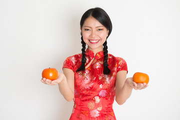 Asian chinese girl holding tangerine