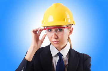 Young businesswoman with hard hat on white