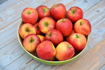 Verse appels in groene fruitschaal op oud hout