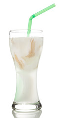 Fresh coconut juice in a glass with meat and green straw isolate