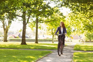 Naklejka premium Pretty redhead cycling a bike