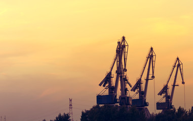 Dock crane silhouettes at sunset