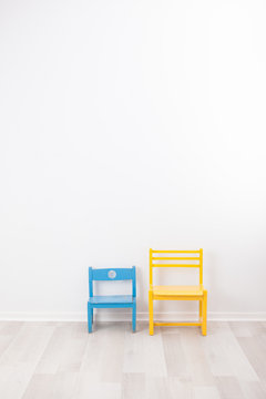 Two Vintage Child Chairs On White Wall