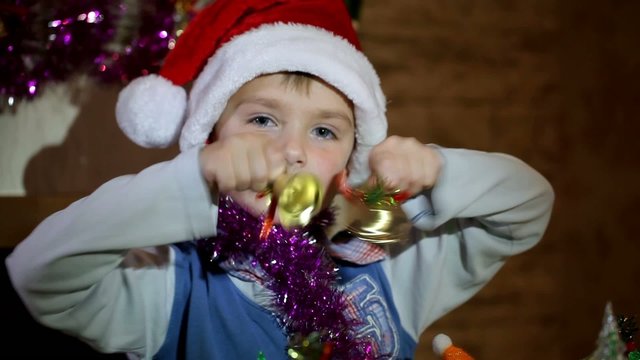 Boy playing with Christmas toys and bells