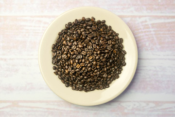 White round plate with a heap of coffee beans