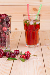 Cherry smoothie on the wooden background.
