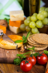 Cheese with fork on wooden board