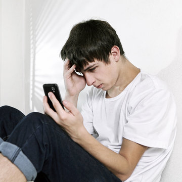 Sad Teenager with Cellphone