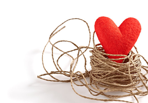 Valentines Day. Red handmade heart in nest of twine
