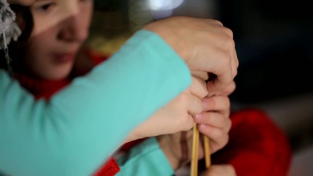 Girl girlfriend teaches creative weaving of threads