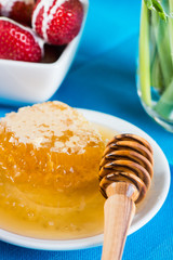 close view on fresh honney with comp and wooden dipper