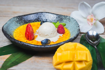 scoop of ice cream on a plate with fresh berries and creme