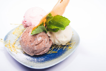 Three scoops of chocolate, strawberry and vanilla ice cream in