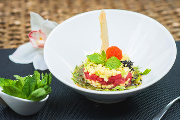 Elegant salad Tartar with herring, avocado, lettuce, restaurant