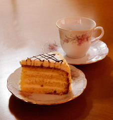 Piece of cake and cup of tea, selective focus