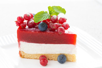 piece of delicious cheesecake with berry jelly on a white plate