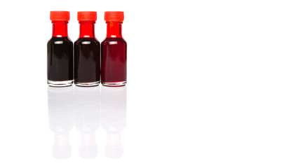 Liquid deep red food color additive over white background