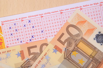 Lottoschein und Banknoten