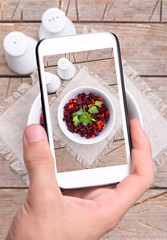 Hands taking photo beet salad with smartphone
