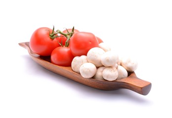 Tomatoes and mushrooms on wooden tray