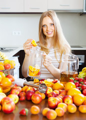 blonde housewife making beverage with fruits