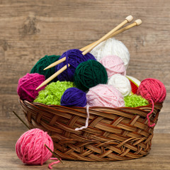 Colorful yarn balls in wicker basket. Selective focus.