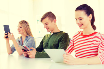 smiling students with tablet pc at school