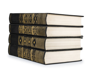 stack of vintage books black with gold pattern on a white backgr