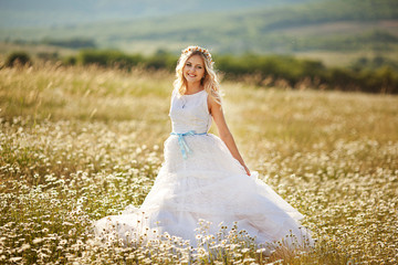 Fototapeta na wymiar beautiful girl in dress on the daisy flowers field