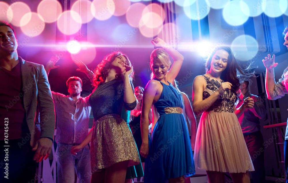 Wall mural smiling friends dancing in club