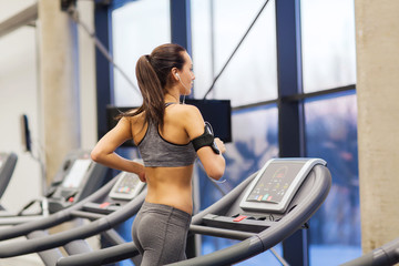 woman with earphones exercising on treadmill