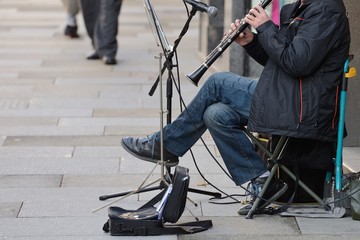 man playing a wind instrument in the street - Powered by Adobe