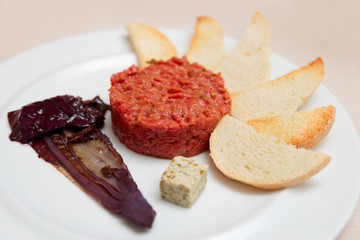Tartare with toasts and chicory cooked in wine