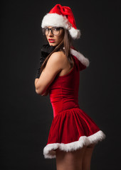 Beautiful brunette woman with retro glasses dressed as Santa