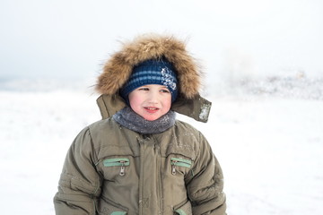 Little boy with a sad face outdoors winter outdoors