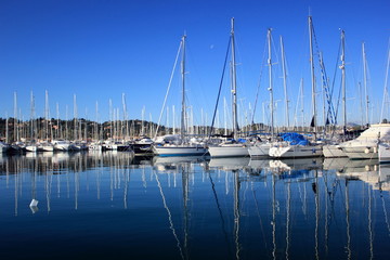 sail Boats and yachts reflected in calm harbour