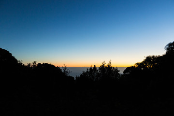 Silhouette atop a mountain with the sunrise.