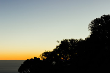 Silhouette atop a mountain with the sunrise.