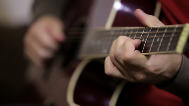 Close up of hands playing guitar - rack focus