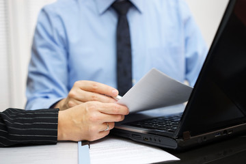 Consultant and client are working with documents and laptop on o