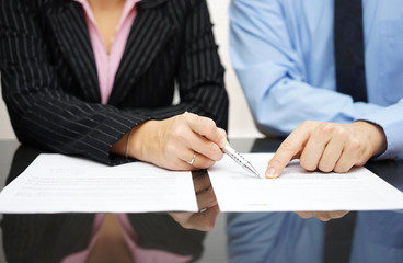 businessman and businesswoman are pointing to .article of the tr