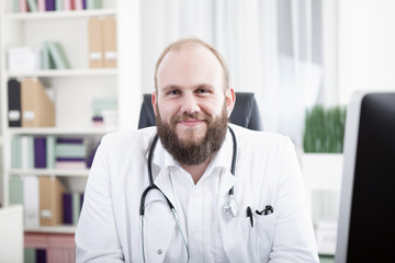 Portrait eines glücklichen Arzt an seinem Schreibtisch