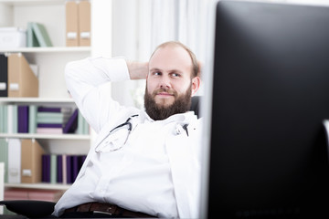 Fototapeta premium Arzt sitzt entspannt am Schreibtisch