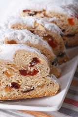 fruit bread Stollen sliced macro on a white plate. vertical