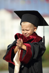 funny kid dressed as a graduate of the University